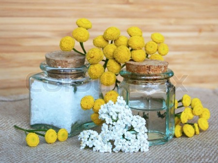 3120790-bottles-of-essential-oil-and-sea-salt-with-yellow-camomiles-in-spa-composition